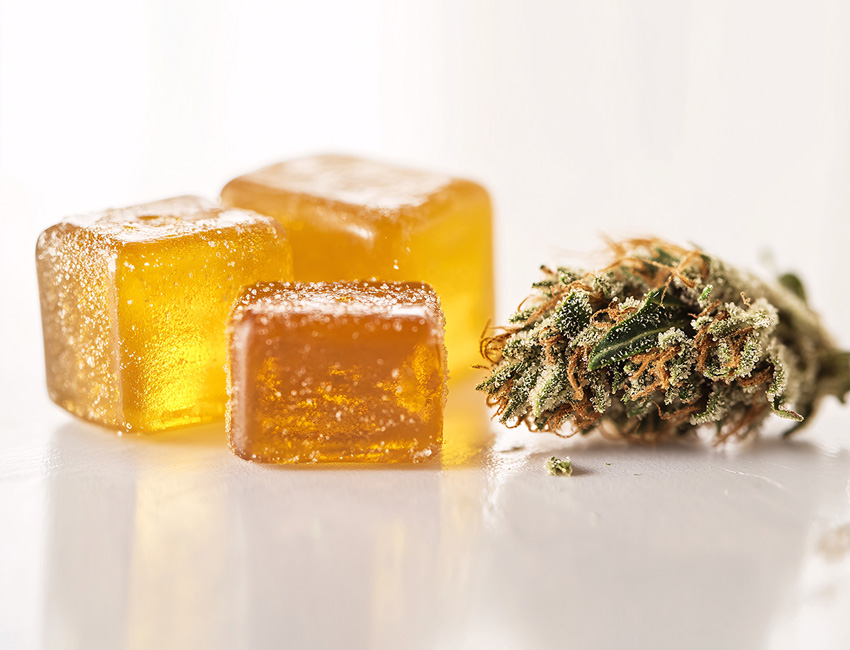 THC-infused cannabis gummies with a cannabis bud at Huff and Puff Dispensary